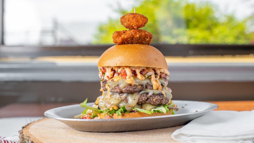 Fiery Smokehouse Burger · Two burger patties, pepper jack cheese, greens, pico de gallo, pickled jalapeños, jalapeño poppers and our chipotle aioli.
