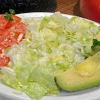 Ensalada De Tomate Y Aguacate · Avocado and Tomatoes served on a bed of lettuce