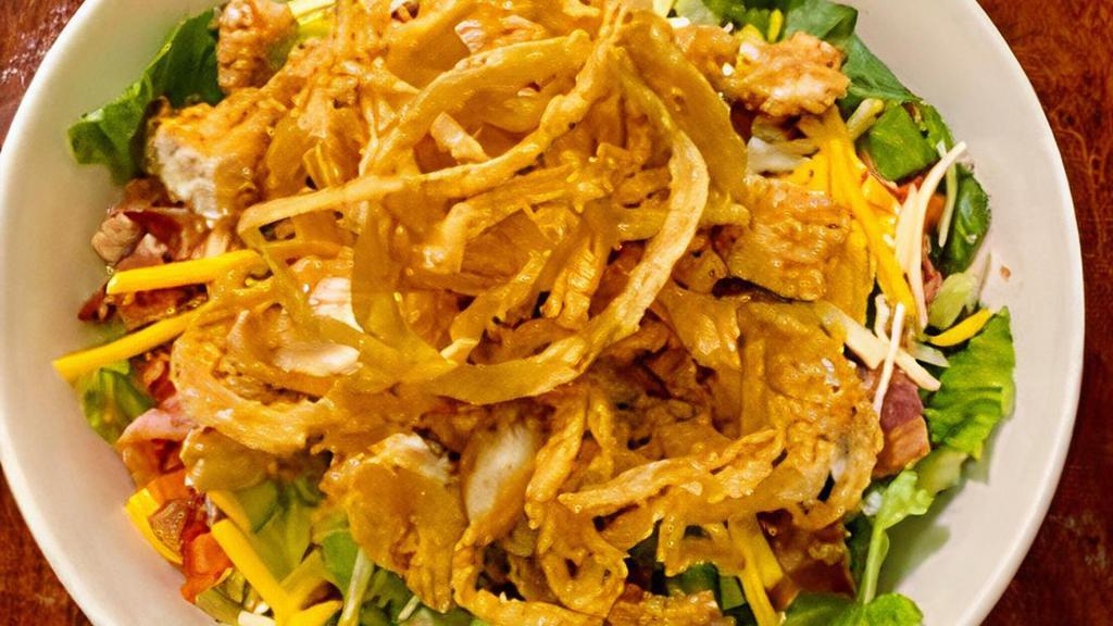 Tender Salad · Hand battered crispy chicken tenders on a bed of field greens tossed in honey mustard with Monterey Jack & Cheddar cheeses, tomato, cucumber and crispy bacon. Topped with frizzled onions.