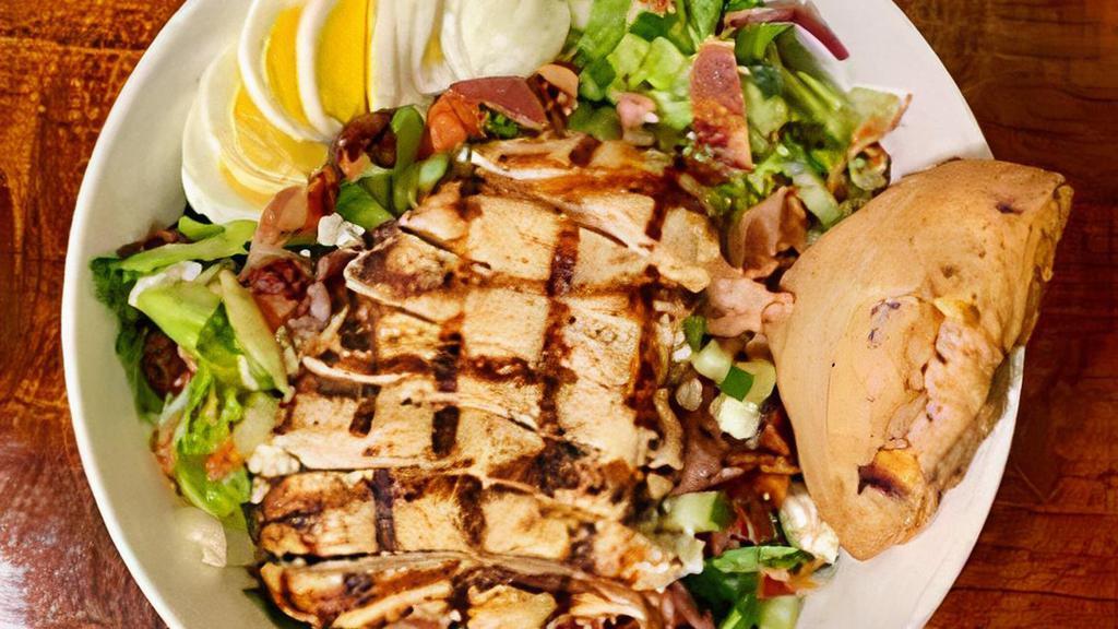 Chopped Chicken Salad · Grilled chicken, mixed greens, tomato, cucumber, red onions, Kalamata olives, bleu cheese, hard-boiled egg & bacon. Chopped and tossed in your choice of dressing. Served with a fresh scone.