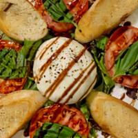 Caprese Salad · Fresh tomatoes, basil and Burrata mozzarella served on a bed of baby greens in light vinaigr...