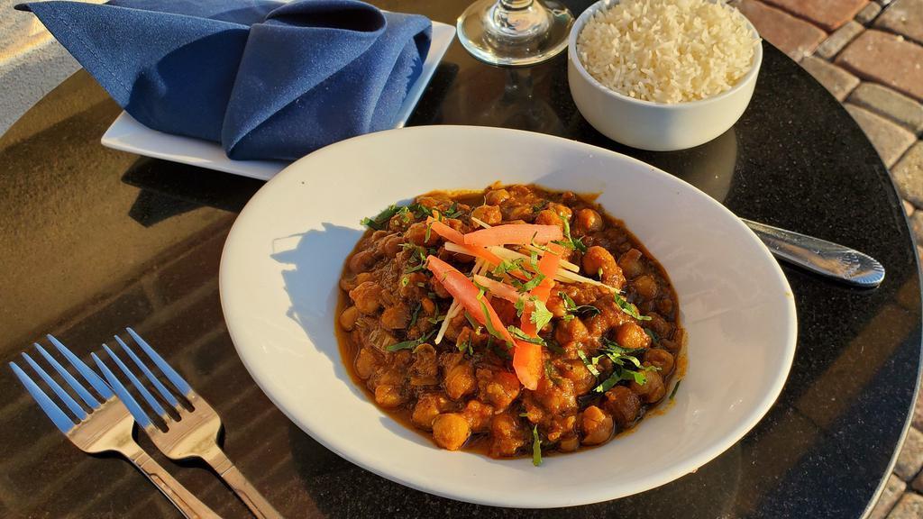 Chana Masala  · Spiced chick peas curry cooked in tomato onion sauce with chana masala