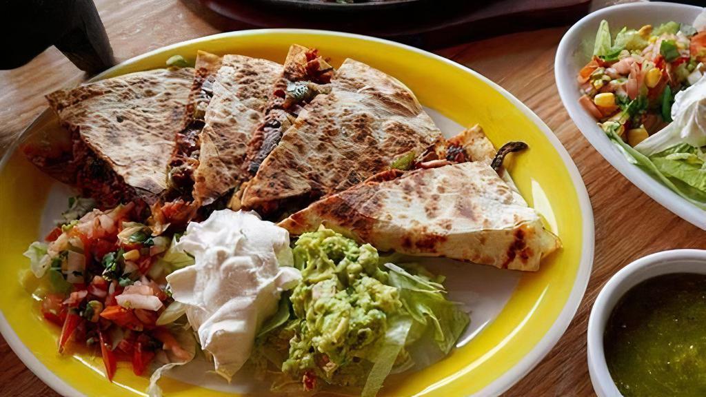 Quesadilla Clasica · 12” flour tortilla stuffed with cheese and your choice of protein. Served with salad, guacamole and sour cream.