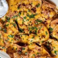 Irish Nachos · Thin fried potato slices with Cheddar cheese, bacon and chives. Served with sour cream.