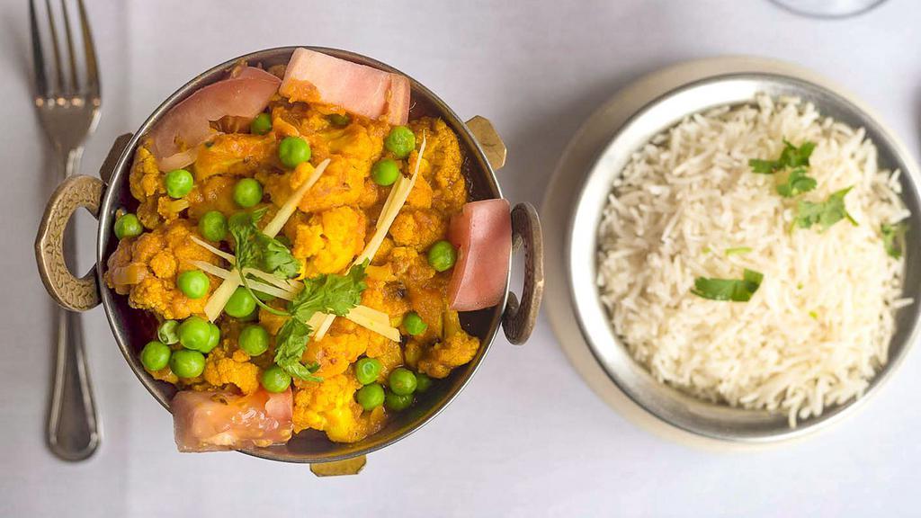 Gobi Masala · Vegan. Fresh cauliflower and potatoes cooked with ginger, tomatoes, peas, and mild spices.