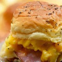 Egg, Ham Cheese Breakfast Sandwich · Two scrambled eggs with cheddar cheese and three slices of Canadian bacon on a buttered brio...