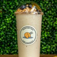 Pb Banana Smoothie · Peanut butter banana smoothie with granola and blueberry on top.