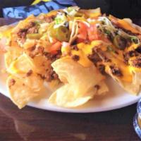 Ultimate Nachos · Tortilla chips loaded with cheese, tomatoes, black olives, jalapeños & green onions. Served ...