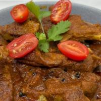 Lal Maas (Goat Curry) · bone-in chunks of tender goat slowly cooked in spices, yogurt and red chili sauce