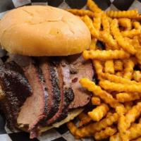 Beef Brisket Sandwich · Smoked brisket piled high on a bun served with one side