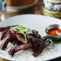 Thai Beef Jerky · Deep fried marinated beef strips served with spicy sriracha sauce.