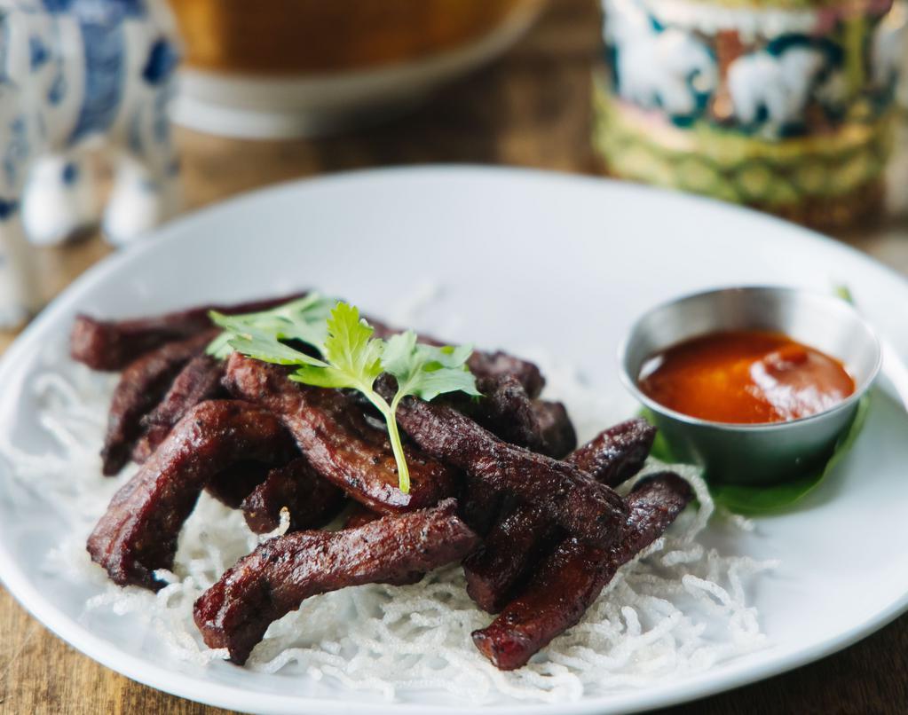 Thai Beef Jerky · Deep fried marinated beef strips served with spicy sriracha sauce.