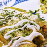 Green Chili Chicken Enchiladas · Three corn tortillas filled with chicken, topped with salsa verde, sour cream, cotija, and a...