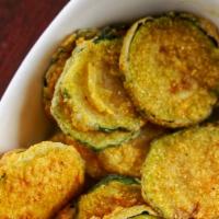 Zucchini Chips · Fried zucchini chips coated in bread crumbs and parmesan cheese with ranch on the side.