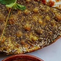 Za'Atar Manaeesh · Baked flatbread topped with lebanese herbs, sesame seeds and olive oil.