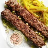 Kafta · 2 skewers of grilled marinated ground beef with parsley.  Served on a bed of Rice.