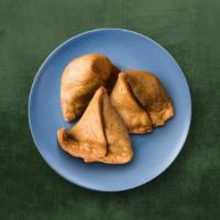 Veggie Samosa · Three pieces. Triangular pastry with a savory filling of spiced potatoes, peas, and lentils....