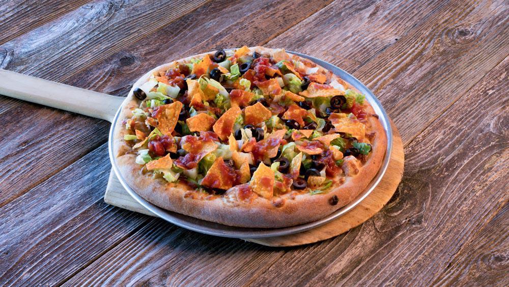 Taco Pizza · Choice of grilled chicken or ground beef with refried beans and taco seasoning. Topped with black olives, salsa, shredded lettuce and nacho chips.