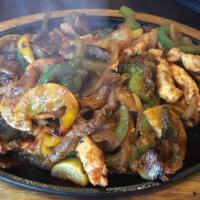Flaming Cheese Fajitas · Grilled strips of chicken and steak, covered with flaming melted cheese. All fajitas are coo...