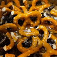 Caramel Pretzel Oreo Cheesecake · Begin with a vanilla cheesecake, topped with Oreo crumble, Ghirardelli Caramel drizzle & Min...