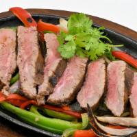 Fajita Steak · Our classic fajitas served on a sizzling hot skillet with grilled onions and peppers, sour c...