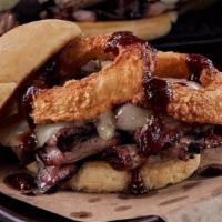 The Z-Man · Slow-smoked beef brisket, smoked provolone cheese, topped with onion rings, on a toasted Kai...