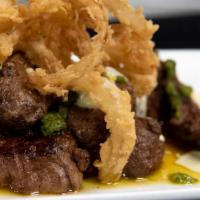 Steak Bites · tender cajun steak bites drizzled with basil, pesto & chive sauce, topped with crispy onions