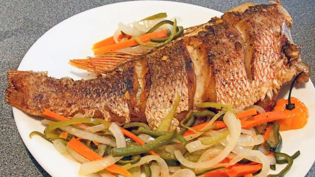 Escovitch Fish Meal · Fried Snapper fish. Seasoned with the best spices. Drenched with onions bell peppers, carrot and vinegar.