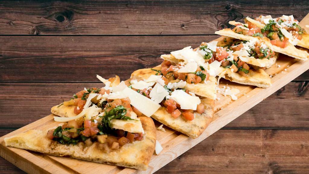 Bruschetta Flatbread · Topped with extra virgin olive oil, roma tomatoes, garlic, basil and parmesan cheese.