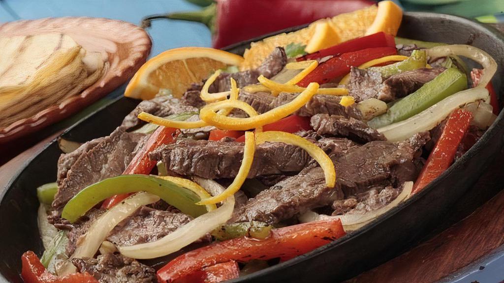 Fajita Steak · Tender strips of marinated skirt steak, sautéed onions, bell peppers, and tomatoes. Served with flour tortillas, lettuce, guacamole, sour cream, pico de gallo, rice, and beans.