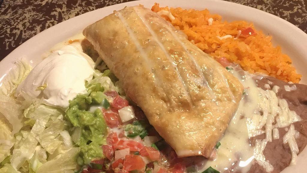 Chimichanga · One flour tortilla stuffed with your choice of spicy chicken or beef chunks and then fried. Topped with cheese sauce, lettuce, tomatoes, cheese, sour cream, rice, and beans.