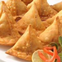 Samosa · Triangular shaped flaky pastry filled with potato and spices (2pcs). Served with mint, cilan...
