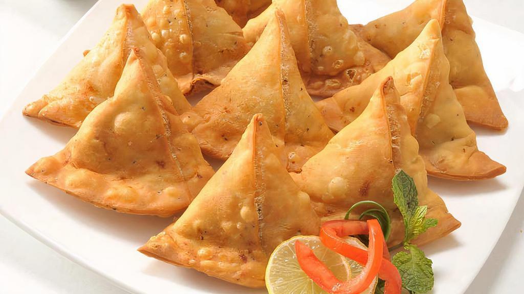Samosa · Triangular shaped flaky pastry filled with potato and spices (2pcs). Served with mint, cilantro chutney and tamarind chutney