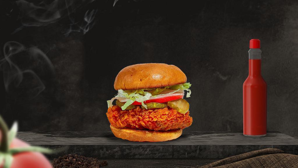 Hot Shot Fried Chicken Sandwich · Vegan crispy chicken tenders tossed in spicy chili oil, peri peri seasoning, lettuce, pickle chips, ketchup on a grilled brioche bun with house chips.