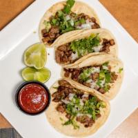 Street Tacos · Four slider tacos with chopped steak, cilantro, diced onion, lime and hot sauce.