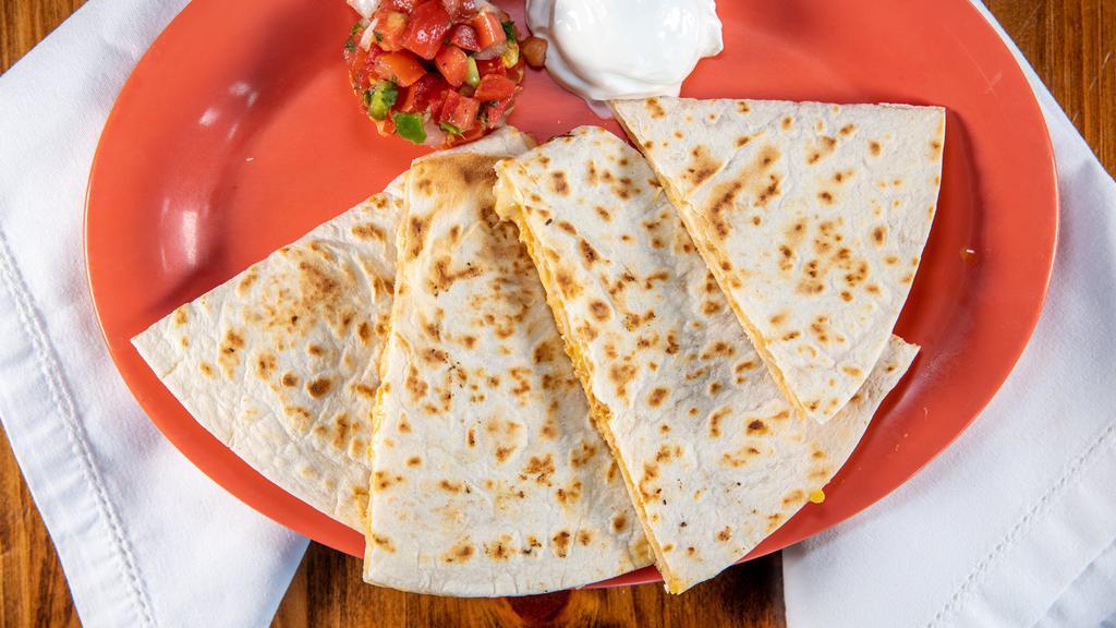 Shredded Chicken Quesadilla · Grilled flour tortillas stuffed with shredded chicken, shredded cheese, pico de gallo, and garlic sauce. Served with a side of sour cream and pico de gallo. 1010 calories.