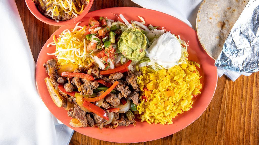 Fajita Beef Plate · Served with three flour tortillas, guacamole, lettuce, sour cream, shredded cheese, pico de gallo, grilled peppers and onions with your choice of two sides. 790 calories.