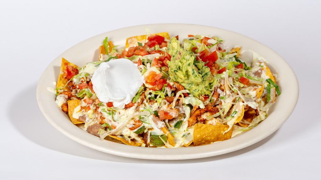Fajita Nachos · Fresh tortilla chips, beans, your choice of fajita meat chicken or steak, white queso dip and topped with lettuce, tomatoes, sour cream and guacamole.