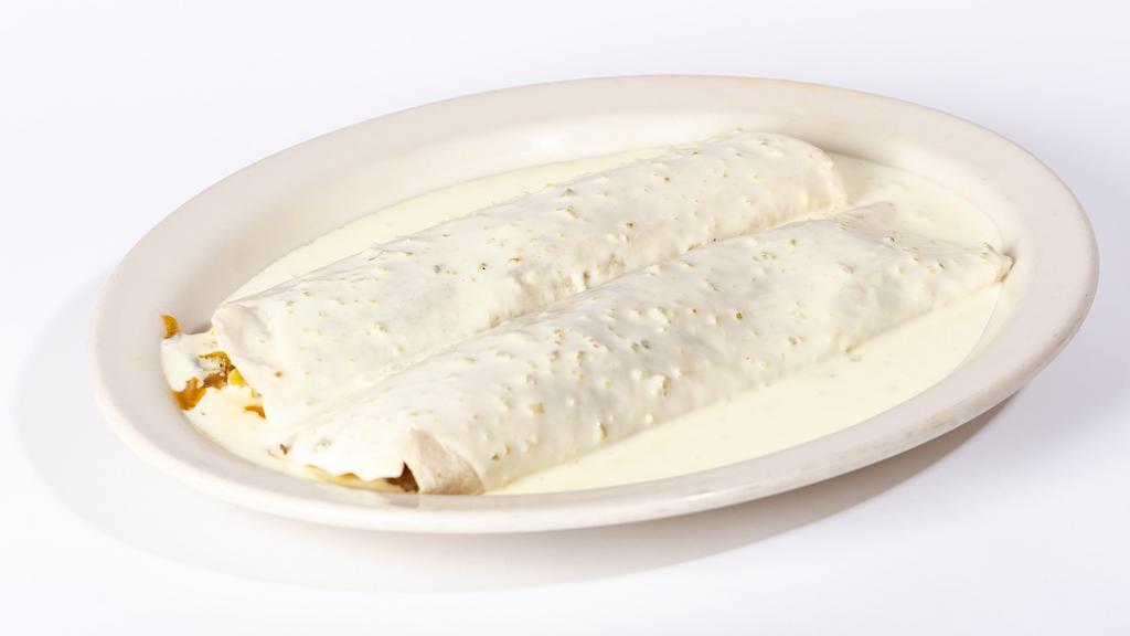 Philly Steak Burritos · Two burritos filled with steak, bell peppers, onions and mushrooms. Topped with our white queso dip.
