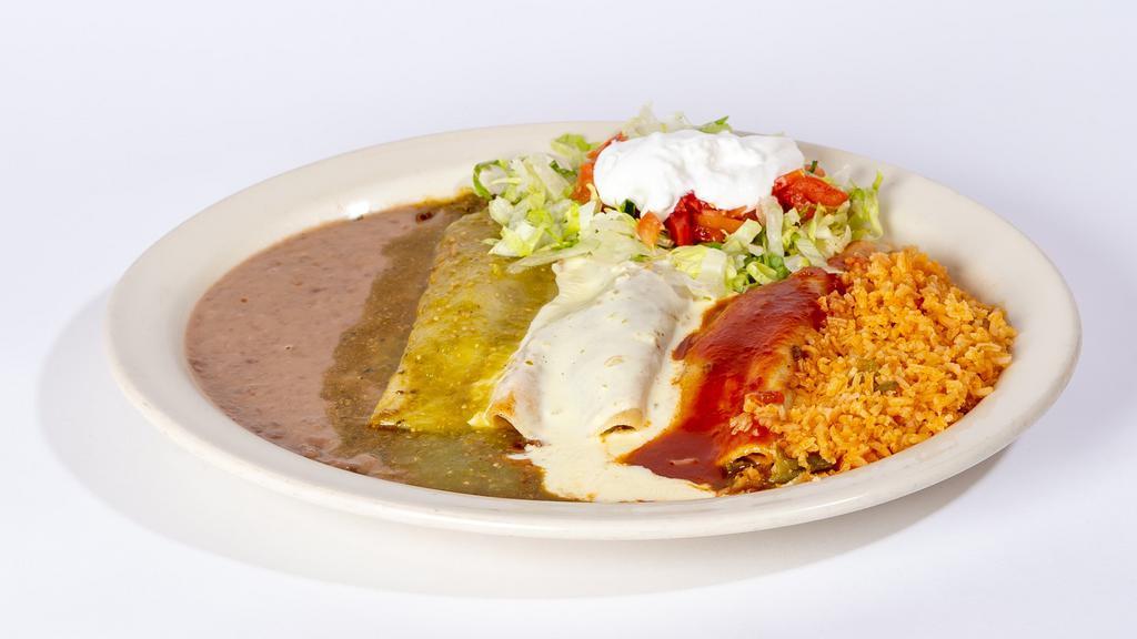 Enchiladas Tricolor · Three enchiladas stuffed with steak or grilled chicken. One topped with green sauce, one topped with red sauce and one topped with white queso dip. Garnished with lettuce, tomatoes and sour cream. Served with rice and beans.