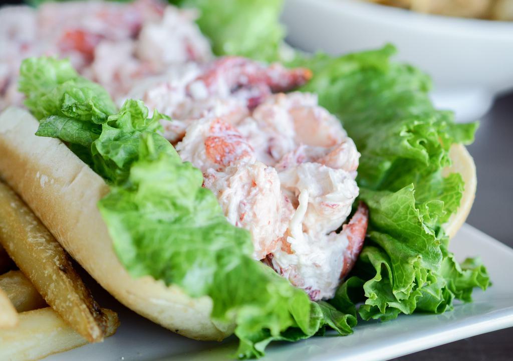 Lobster Roll · 100% real lobster lightly tossed in mayonnaise served in a grilled torpedo roll with green leaf lettuce. Served with French fries and coleslaw.