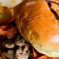 Mushroom Swiss Cheeseburger · Burger piled high with fresh sautéed mushrooms and topped with Swiss cheese, served on a gri...