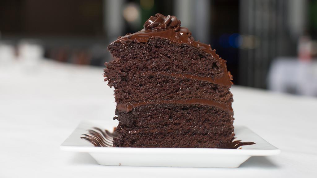 Chocolate Fudge Cake Slice · Four layers of chocolate, piled high with rich chocolate fudge. A chocoholic's dream.