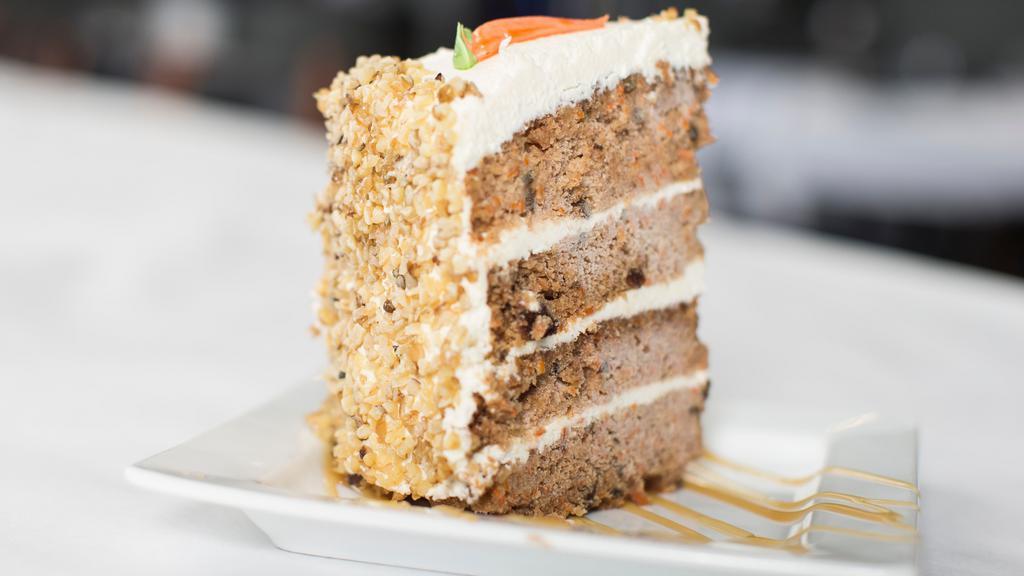 Carrot Cake Slice · A fresh blend of carrots with walnuts, raisins, and spices, glazed with rich cream cheese icing and covered with nuts.