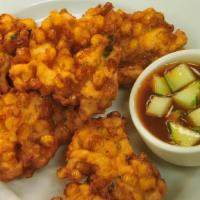 Corn Patties · Sweet corn battered and deep-fried golden brown. Served with cucumber sweet sauce.