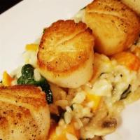 Seared Colossal Scallops · Over a bed of seasonal risotto.
