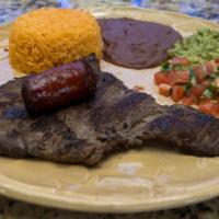 Churrasco A La Plancha · Skirt steak served with rice, beans, chorizo, guacamole, and pico de gallo.
