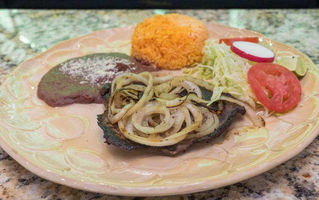 Bistec Encebollado · Grilled steak served with rice, beans, and a house salad.