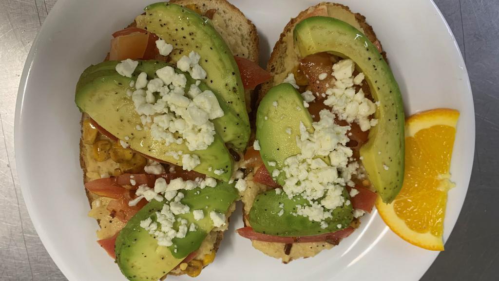 Hummus Toast · Your choice of toast smothered with hummus and layered with roasted corn, avocado, tomatoes and topped with feta cheese.  This toast is seasoned with crushed red pepper, S&P and a drizzle of olive oil.  This is served open faced.