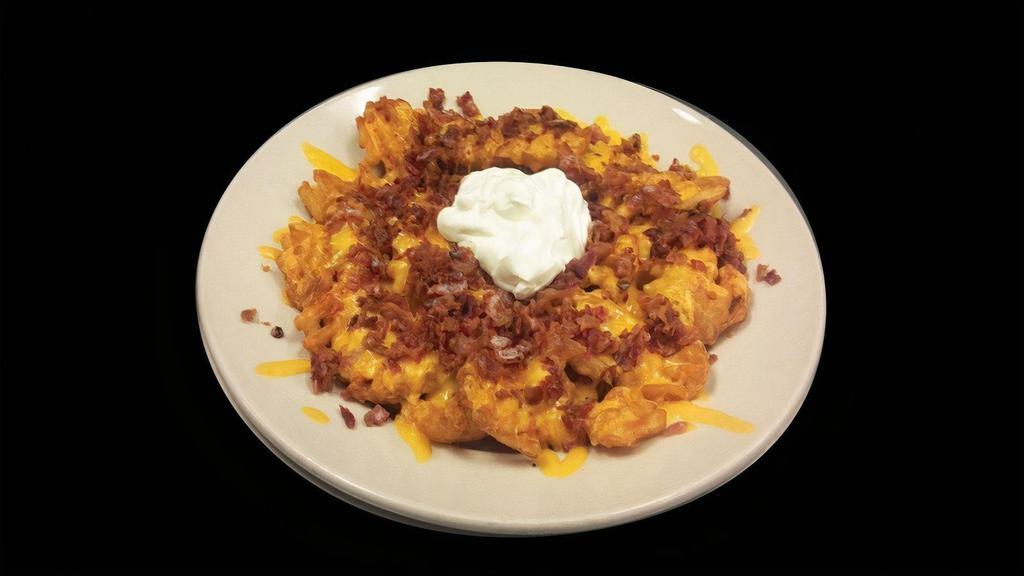 Loaded Fries · Top our traditional waffle fries with cheddar cheese, loads of bacon, sour cream and jalapenos if you please.